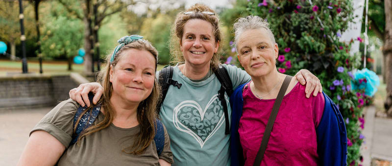 Three people standing together at an ovarian cancer group event